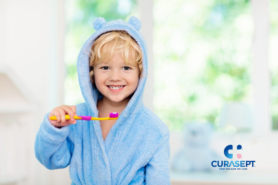 CURASEPT-bimbo-con-spazzolino-kid-biosmalto-AdobeStock_247374796